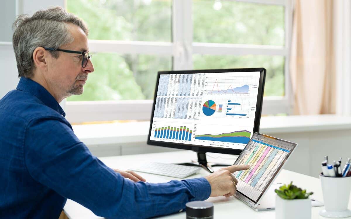 man looking at numbers on a mac